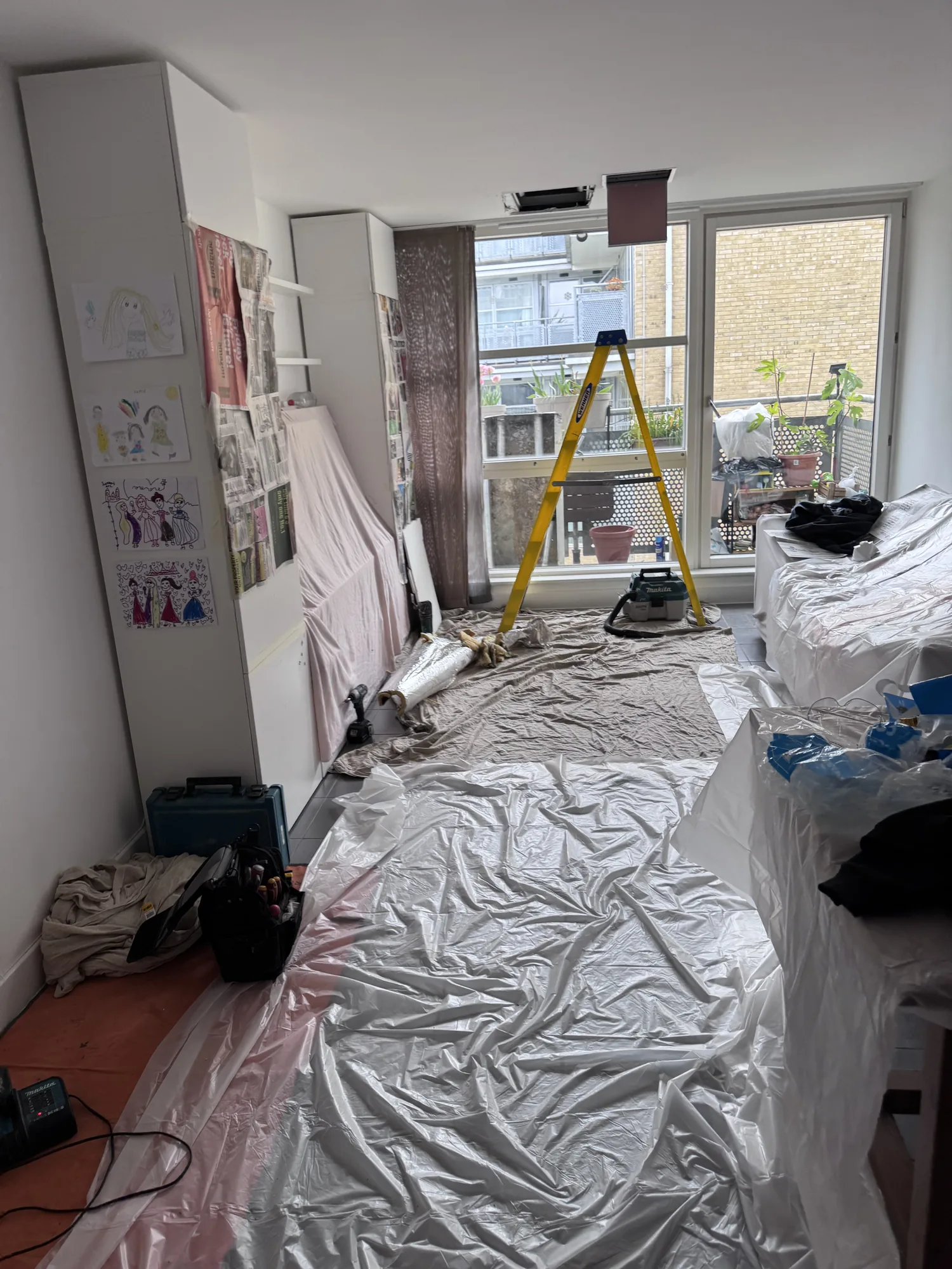 Living room fully protected with dust sheets before heating work, Essex