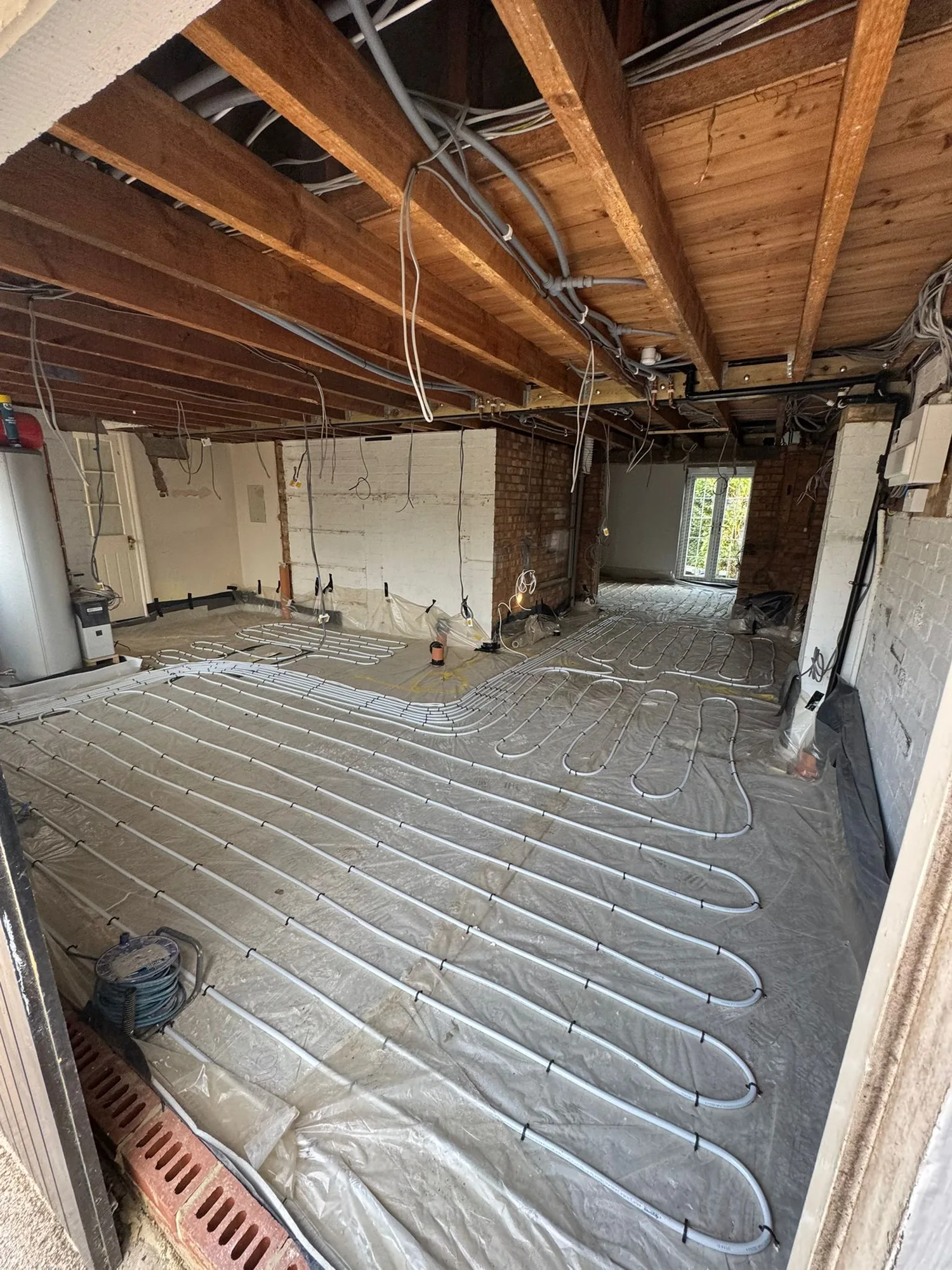 Wet underfloor heating pipework laid before screed pour, Dunmow extension